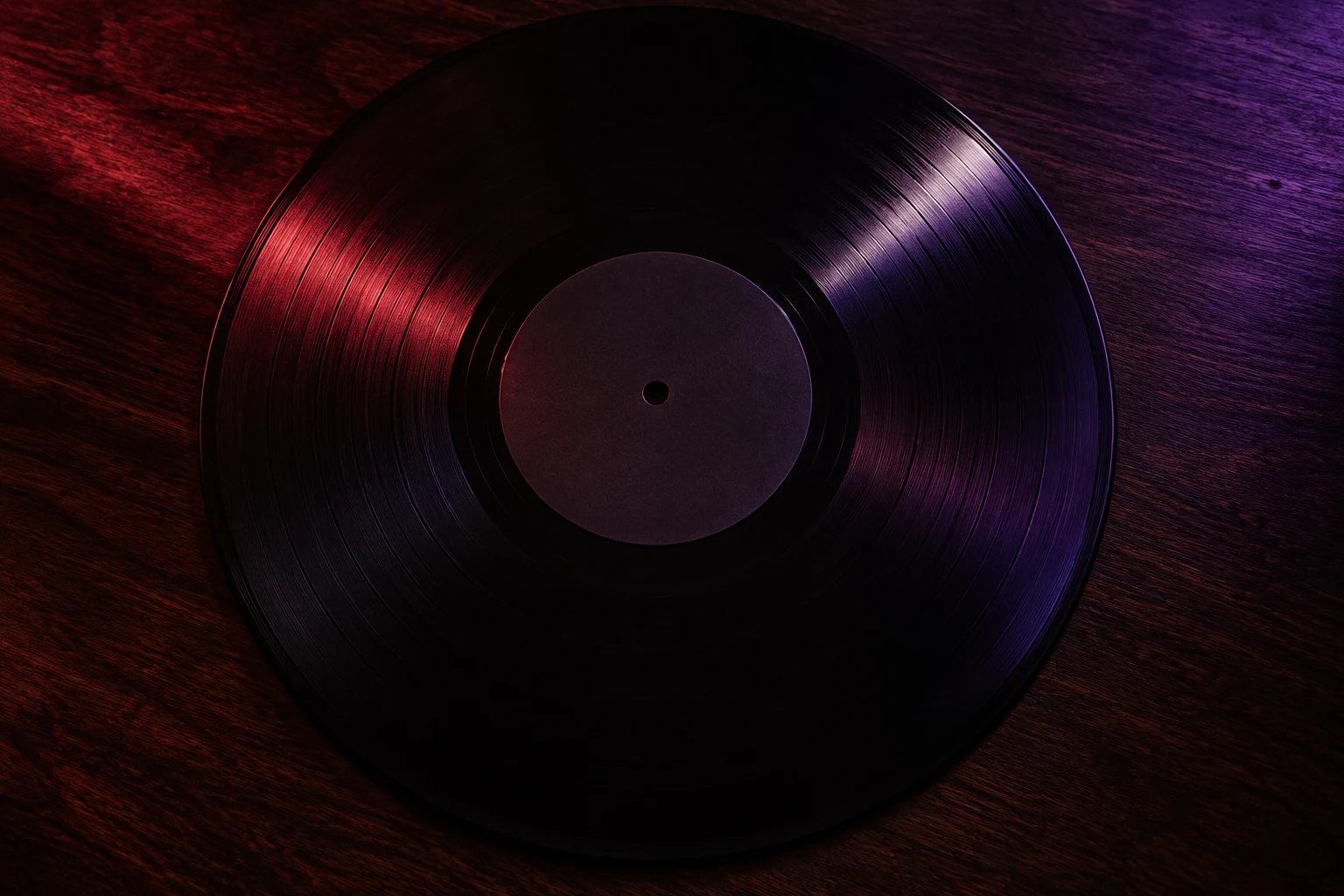 A black vinyl record casting red and violet shadows across a dark wood surface.