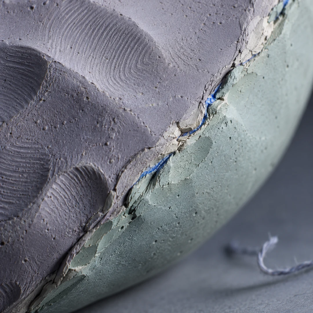 A macro view of fingerprints and a repaired seam on an abstract clay surface under precise studio light
