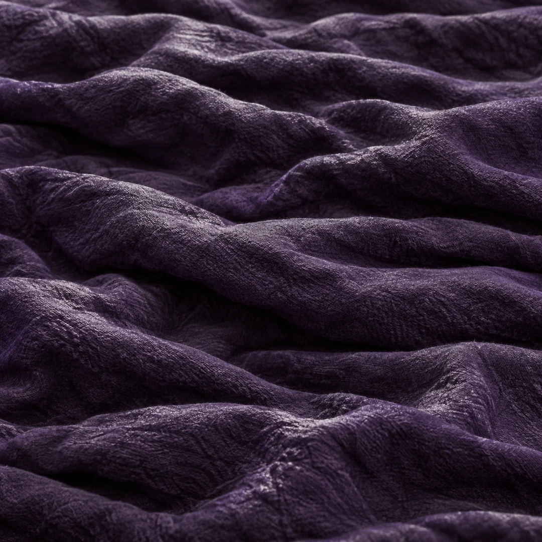 Macro view of deep violet textile ridges with charcoal shadows and small silver highlights